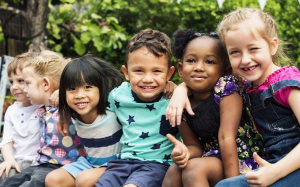 Kinder sitzen und schauen in die Kamera