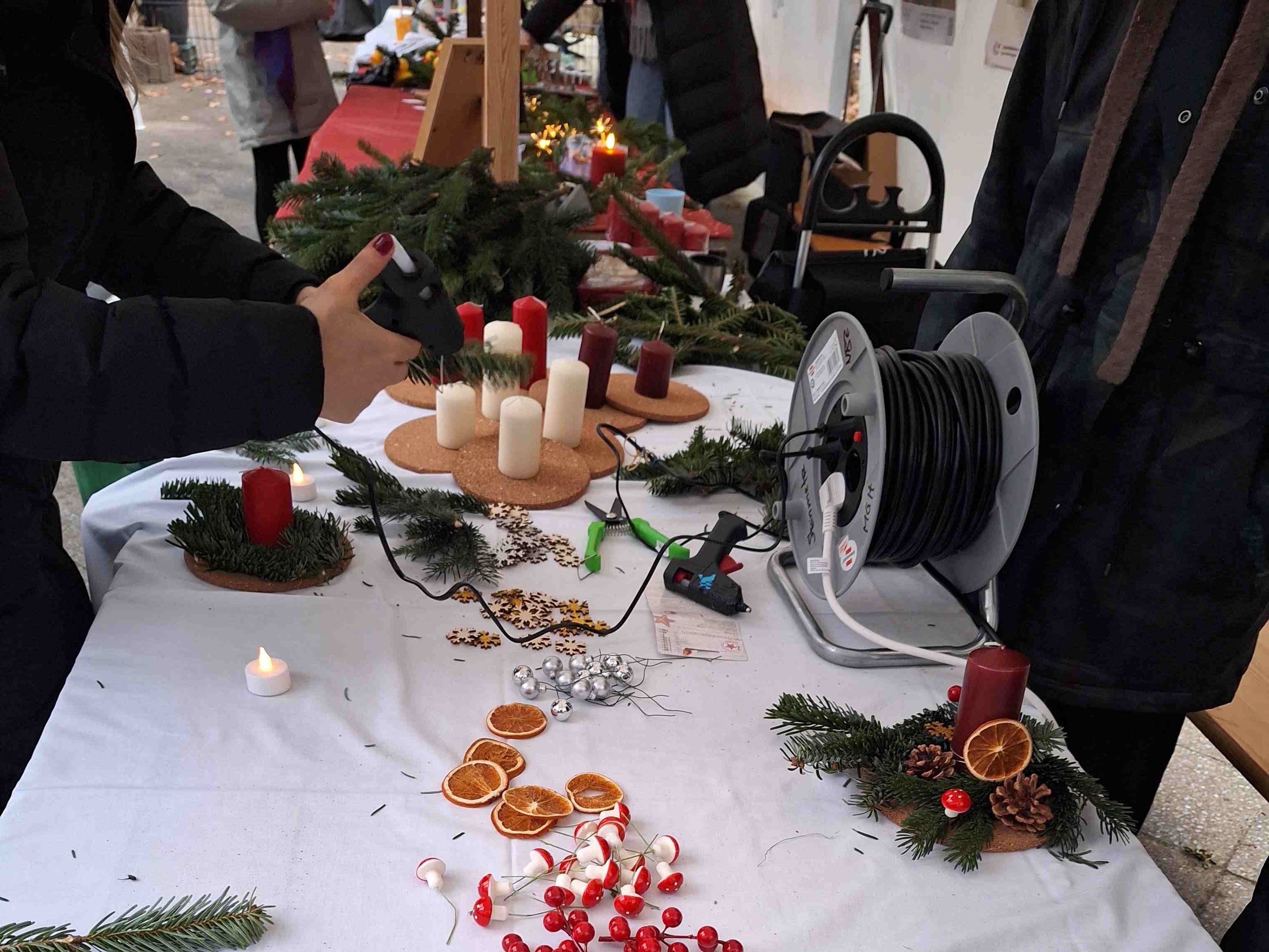 Eine Person bastelt ein Adventsgesteck.