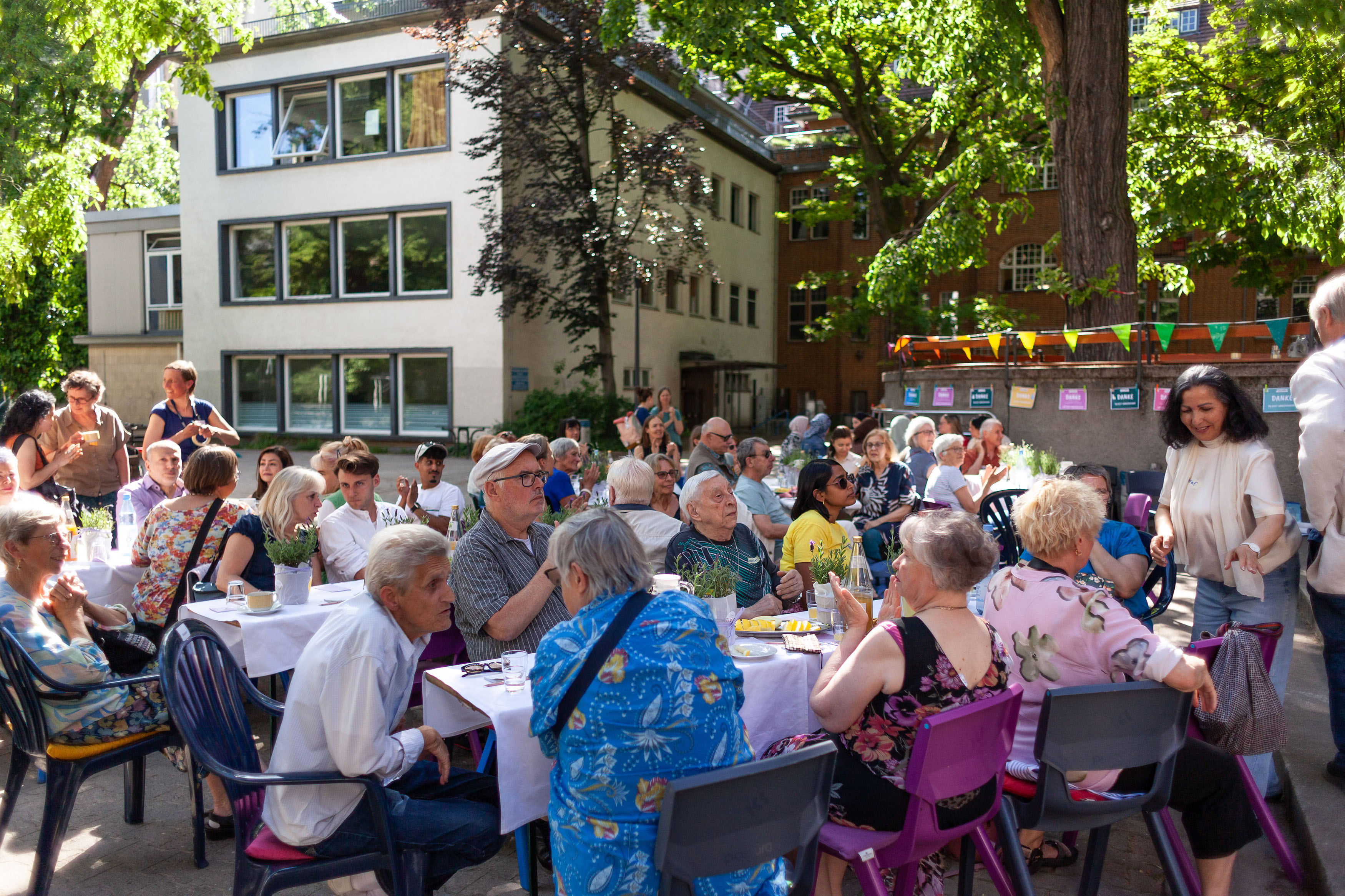 Auf dem Campusgelände sitzen die Ehrenamtlichen in Tischgruppen zu jeweils 8-10 Personen.
