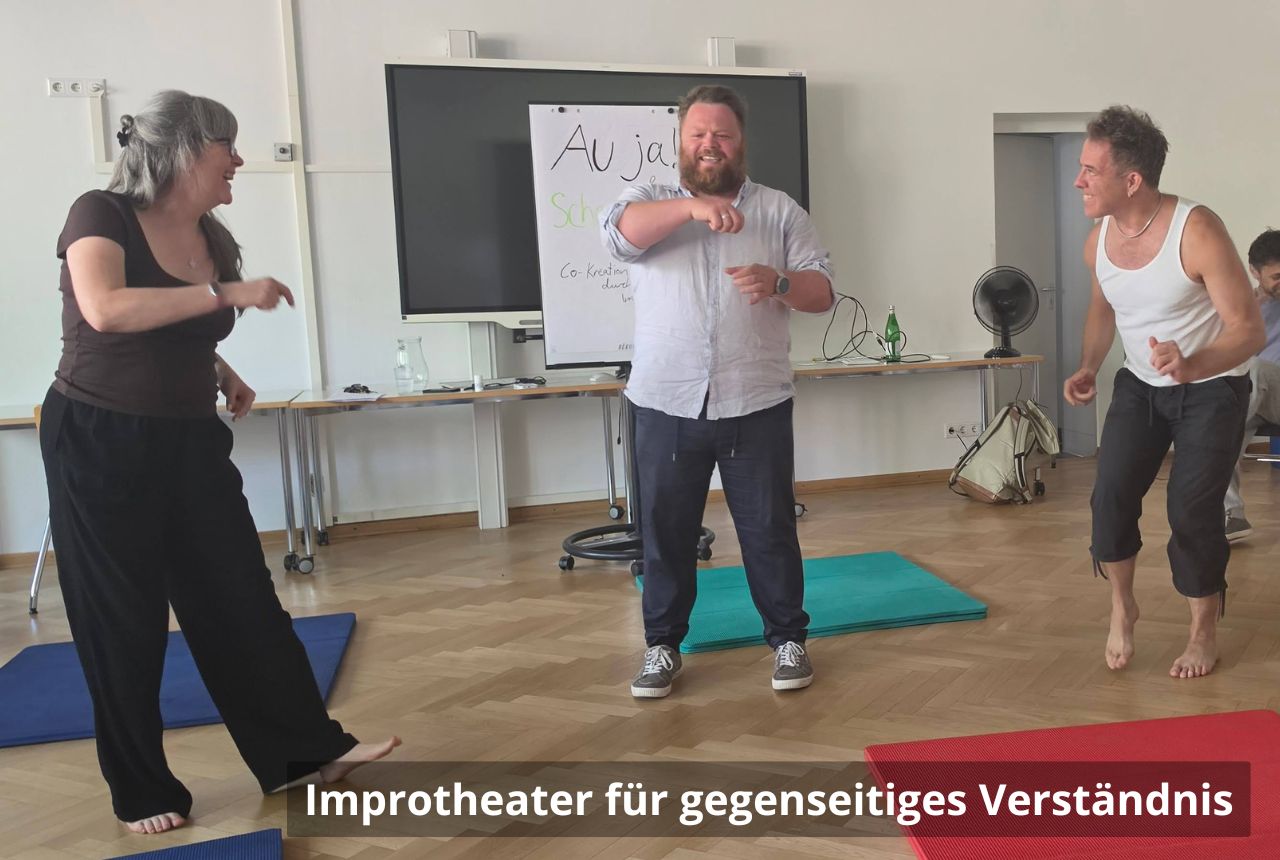 Drei Personen stehen im Halbkreis. Sie sind in Bewegung und lachen.