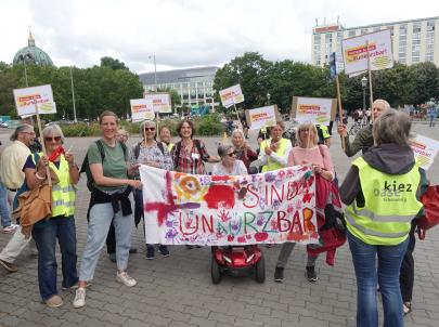 Soziale Arbeit ist #unkürzbar! Mitarbeiter*innen des PFH (Kiezoase) demonstrieren vor dem Roten Rathaus mit Schildern.