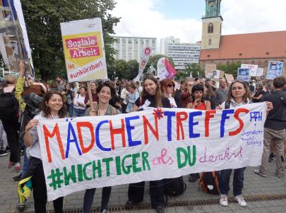 Mädchen*treffs sind wichtiger als du denkst! Mitarbeiter*innen des PFH (Café Pink) demonstrieren vor dem Roten Rathaus mit Schildern.