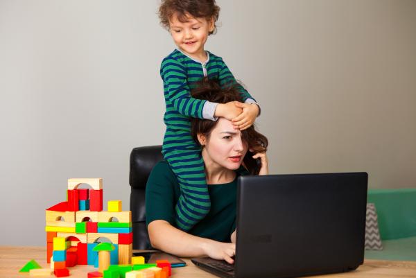 Arbeitende Mutter im Home Office mit Kind