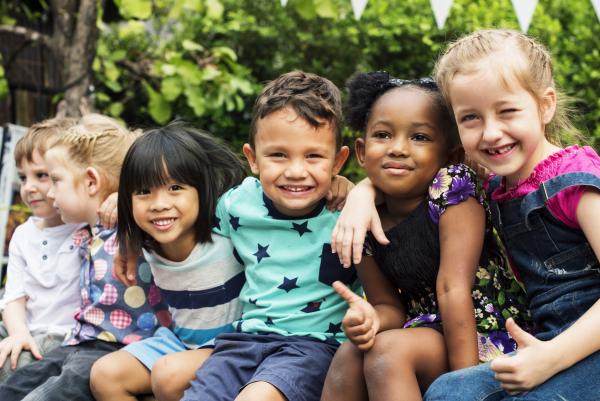 Kinder sitzen und schauen in die Kamera