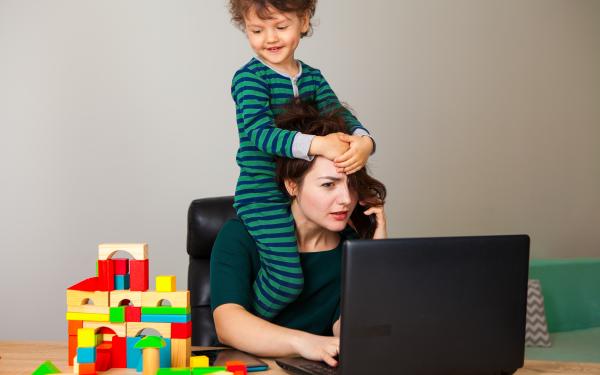 Arbeitende Mutter im Home Office mit Kind