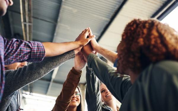 Gruppe Studierende, die sich High Five gibt